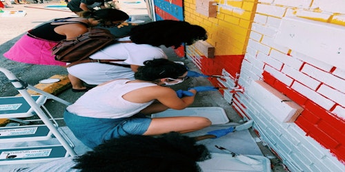 people painting exterior of outdoor market