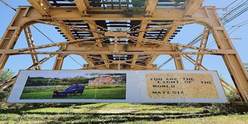 display of market banner and art underneath train