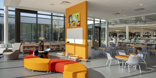 Image of interior of library with orange seating and books